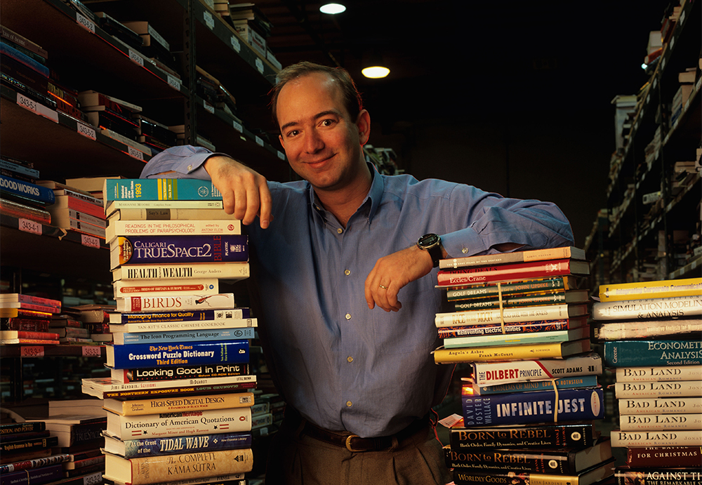 Amazon president Jeff Bezos with stacks of books inside huge warehouse in Seattle, 1998 (Worldfoto/Alamy)